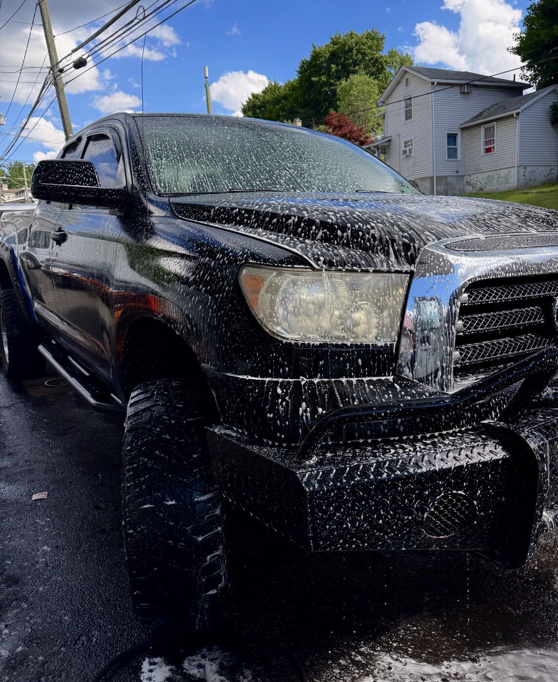 Hand wash and foam bath on a lifted truck exterior